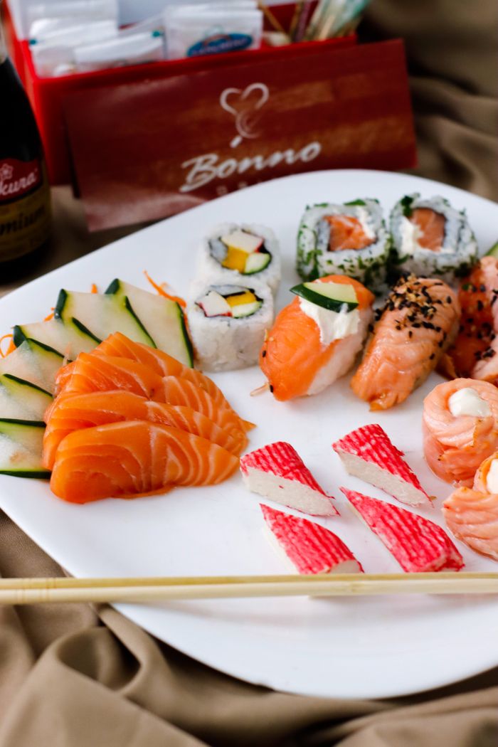 A beautifully arranged sushi platter featuring salmon sashimi, maki rolls, and crab sticks, perfect for gourmet dining.