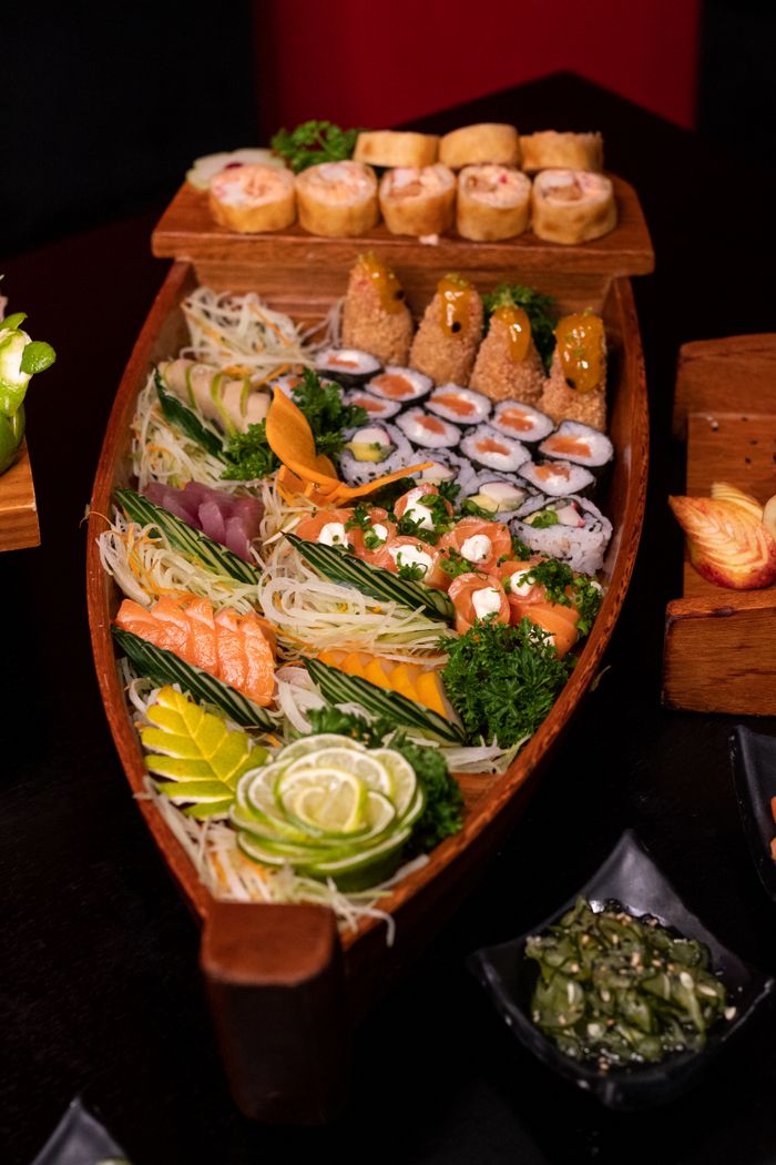 A colorful assortment of sushi and sashimi served on a wooden boat platter, ideal for authentic Japanese dining.