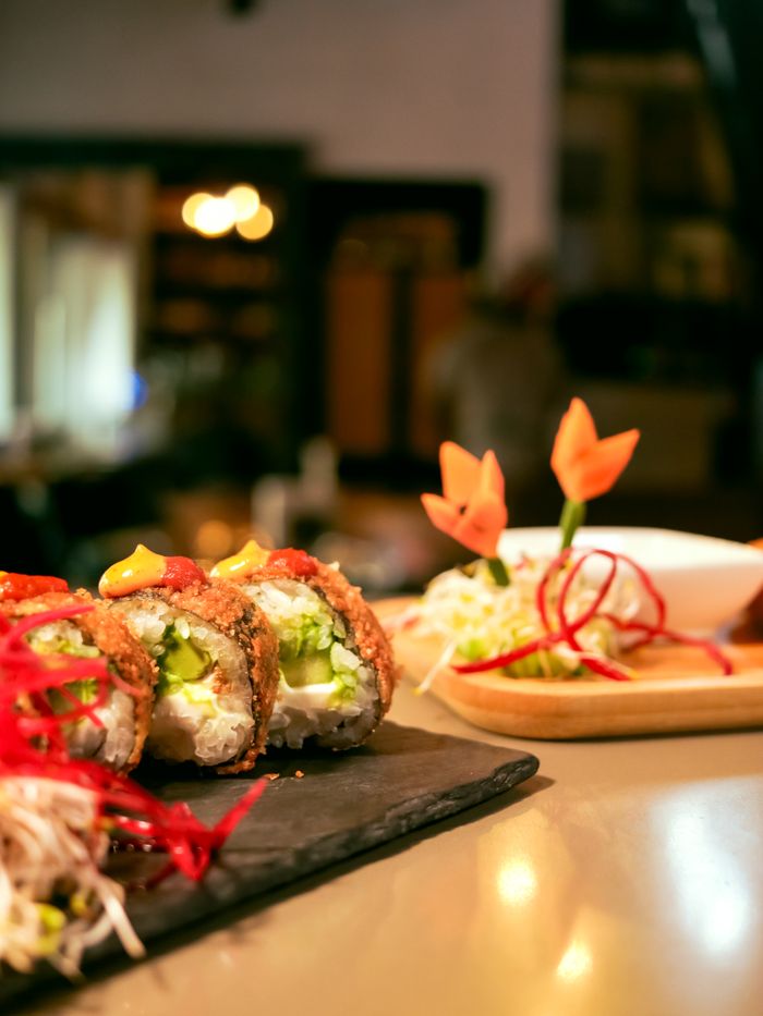 our-experience Close-up of gourmet sushi rolls with elaborate garnish, perfect for culinary themes.